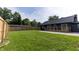 Large fenced in backyard with green grass and a stained wood deck at 6555 Michigan Rd, Indianapolis, IN 46268