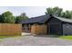 Home featuring a dark exterior, fenced yard, and gravel driveway at 6555 Michigan Rd, Indianapolis, IN 46268