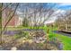 A serene backyard oasis with a rock-lined pond, mature trees, and flowering plants creates a tranquil escape at 7002 Oakbay Cir, Noblesville, IN 46062