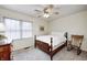 Cozy bedroom with a wooden bed frame, ceiling fan, and natural light from the window at 7002 Oakbay Cir, Noblesville, IN 46062