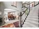 Open foyer with view of dining room, staircase with carpet runner and dark wood banister at 7002 Oakbay Cir, Noblesville, IN 46062