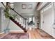 Bright foyer with hardwood floors, staircase, and view of living room through archway at 7002 Oakbay Cir, Noblesville, IN 46062
