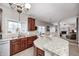 Open kitchen with dark wood cabinets, granite counters, and view to the dining and living rooms at 7002 Oakbay Cir, Noblesville, IN 46062