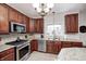 Kitchen features stainless appliances, granite countertops, tile backsplash, and dark wood cabinets at 7002 Oakbay Cir, Noblesville, IN 46062