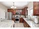 Kitchen features stainless appliances, granite countertops, tile backsplash, and dark wood cabinets at 7002 Oakbay Cir, Noblesville, IN 46062