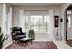 Bright living room featuring large window, comfortable armchair, and decorative rug at 7002 Oakbay Cir, Noblesville, IN 46062