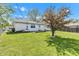 Spacious backyard with green grass, a tree, and a white house, offering a serene outdoor space at 720 Danielle Rd, Lebanon, IN 46052
