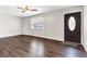 Cozy living room featuring dark wood floors, a ceiling fan, and a view of the front door at 720 Danielle Rd, Lebanon, IN 46052