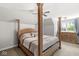 Bright bedroom featuring a stylish four-poster bed with an ornate wooden frame and a large window with natural light at 7259 Josiah Ct, Indianapolis, IN 46259