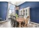Elegant dining room with large windows, a wooden table, and custom cabinetry for storing dinnerware and decor at 7259 Josiah Ct, Indianapolis, IN 46259