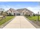 Beautiful white brick home with a spacious driveway, lush lawn, and professional landscaping at 7259 Josiah Ct, Indianapolis, IN 46259