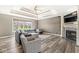 Cozy living room features a fireplace, large windows, and comfortable gray sectional sofa at 7259 Josiah Ct, Indianapolis, IN 46259
