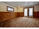 An expansive basement with neutral walls, wood trim, carpet flooring, and a door to the outside at 7367 Parkside Dr, Indianapolis, IN 46226