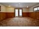 An expansive basement with neutral walls, wood trim, carpet flooring, and a door to the outside at 7367 Parkside Dr, Indianapolis, IN 46226