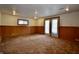 An expansive basement with neutral walls, wood trim, carpet flooring, and a door to the outside at 7367 Parkside Dr, Indianapolis, IN 46226