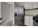 Kitchen area featuring a stainless steel refrigerator and modern white cabinets at 7783 Park N Ct, Indianapolis, IN 46260