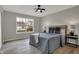Inviting bedroom featuring a ceiling fan, large window and two side tables at 7783 Park N Ct, Indianapolis, IN 46260