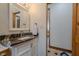 Bathroom featuring a granite vanity with white cabinets and wooden door at 7980 S State Road 135, Columbus, IN 47201