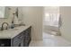 Bathroom with double sinks, marble countertop, and marble-clad bathtub at 7980 S State Road 135, Columbus, IN 47201
