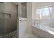 Modern bathroom featuring glass enclosed shower with gray tile and a marble-surround bathtub at 7980 S State Road 135, Columbus, IN 47201