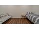 Bedroom with wood floors features a small couch, twin bed with striped bedding, and a small nightstand at 7980 S State Road 135, Columbus, IN 47201
