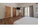 Bedroom with hardwood floors, TV, mirror, area rug, sliding glass doors to outdoor deck at 7980 S State Road 135, Columbus, IN 47201
