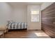 Bright bedroom features wood floors, a window with blinds, and a modern wood sliding closet door at 7980 S State Road 135, Columbus, IN 47201