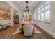 Bright dining room featuring a wooden table, white chairs, wood floors, and large windows at 7980 S State Road 135, Columbus, IN 47201