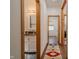 Hallway view of the vanity and mirror, bathroom, and bedroom with wood flooring and bright light at 7980 S State Road 135, Columbus, IN 47201