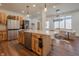 Open kitchen with island, natural wood cabinets, marble countertop, and stainless steel appliances at 7980 S State Road 135, Columbus, IN 47201