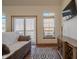 Living room with hardwood floors, TV, area rug, and sliding glass doors to outdoor deck at 7980 S State Road 135, Columbus, IN 47201