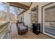 Outdoor porch features a chair, wooden flooring, wooden railing, and a mini-fridge near a window at 7980 S State Road 135, Columbus, IN 47201