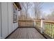Wood-floored porch with wooden railing shows view of greenery in the background at 7980 S State Road 135, Columbus, IN 47201