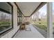 Inviting porch with firewood, concrete flooring, and open view of yard and trees at 7980 S State Road 135, Columbus, IN 47201