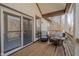 Outdoor porch features two chairs, wood floors, railing, and a view of trees in the background at 7980 S State Road 135, Columbus, IN 47201