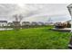 This backyard has a covered table, green grass, black mulch and a black metal fence overlooking a pond at 8405 Whitaker Valley Blvd, Indianapolis, IN 46237