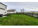 This backyard has a green lawn, a black metal fence, a leafless tree, and black mulch at 8405 Whitaker Valley Blvd, Indianapolis, IN 46237