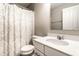 This bathroom has a toilet, sink, mirror, vanity and shower with a curtain at 8405 Whitaker Valley Blvd, Indianapolis, IN 46237