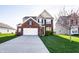 Charming two-story brick home featuring an attached garage and a well-manicured front yard at 8405 Whitaker Valley Blvd, Indianapolis, IN 46237
