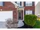 A close-up of the red brick home's black front door and well-landscaped entry way at 8405 Whitaker Valley Blvd, Indianapolis, IN 46237