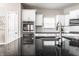 Close-up on granite countertops, a kitchen faucet, and tile backsplash against white cabinets and stainless steel appliances at 8405 Whitaker Valley Blvd, Indianapolis, IN 46237