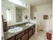 Bathroom vanity featuring double sinks, dark wood cabinets, and a large mirror at 8744 N Aspen Way, McCordsville, IN 46055
