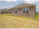 New construction showing a brick home exterior with large windows and a lawn at 895 Saddlebrook Farms Blvd, Whiteland, IN 46184
