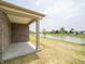 Covered patio overlooking a serene pond and landscaped yard, perfect for outdoor relaxation at 895 Saddlebrook Farms Blvd, Whiteland, IN 46184