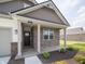 Inviting entrance with brick columns and dark front door complemented by manicured landscaping at 895 Saddlebrook Farms Blvd, Whiteland, IN 46184