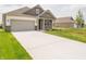 Well-maintained home boasts a concrete driveway, lush green lawn, and inviting covered porch at 895 Saddlebrook Farms Blvd, Whiteland, IN 46184