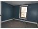This bedroom features blue walls, carpet flooring, and natural lighting from the window at 917 W 27Th St, Indianapolis, IN 46208
