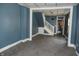 A living room with blue walls, carpeted floors, and an adjacent staircase at 917 W 27Th St, Indianapolis, IN 46208