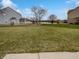 Large backyard with lush green grass and a view of a tranquil pond at 9237 Stones Ferry Pl, Indianapolis, IN 46278