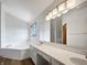 Bright bathroom with a soaking tub, large mirror, and dual sinks set in a white vanity at 9237 Stones Ferry Pl, Indianapolis, IN 46278